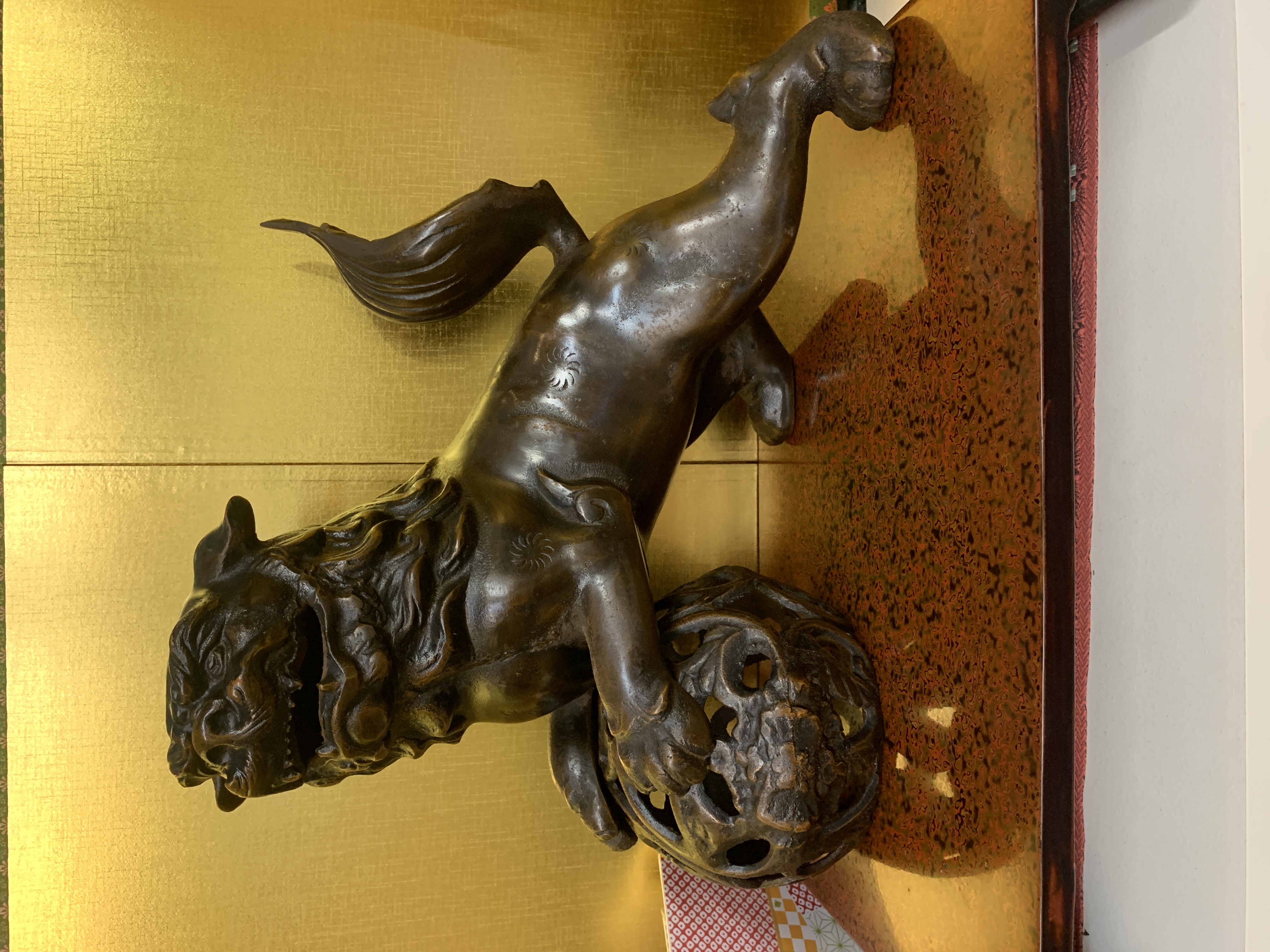 Cast lion dog with globe 